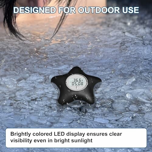 Star-shaped thermometer with LED display on icy surface.